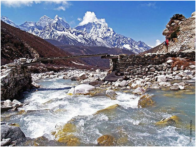 A wooden bridge balanced over glacial melts